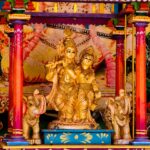 Colorful Radha Krishna shrine featuring elephant figurines and intricate details, symbolizing spiritual art.