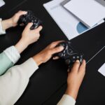 Two people playing video games with controllers, highlighting teamwork and gaming experience.