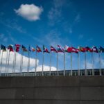 Row of European flags fluttering against a clear blue sky, symbolizing unity.