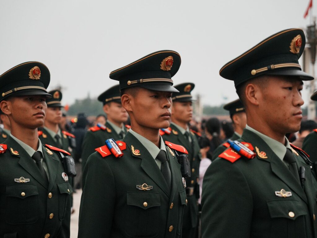 Close-up of military personnel in green uniforms and hats during a parade.