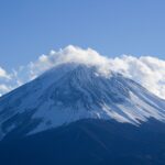 Serene view of snow-capped Mount Fuji under clear blue skies, perfect for nature lovers.