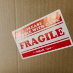 Close-up of a cardboard box with a 'fragile' sticker indicating careful handling.