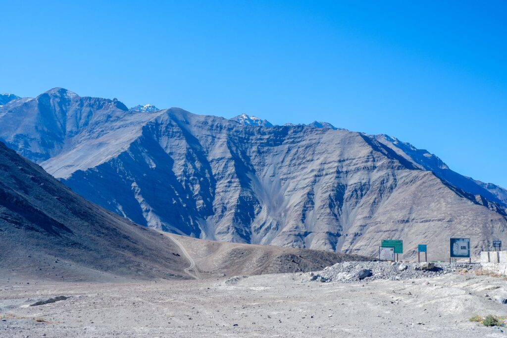 Breathtaking view of Leh's mountain range with unique formations and vibrant blue sky, perfect for travel inspiration.