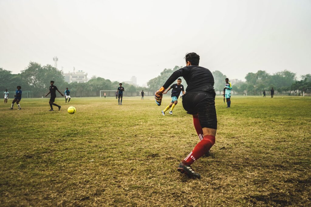 Energetic soccer game with players on a grassy field in India, showcasing teamwork and sportsmanship.