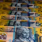 Close-up view of Australian $50 bills arranged in a pattern. Vibrant colors and detailed imagery highlight currency features.