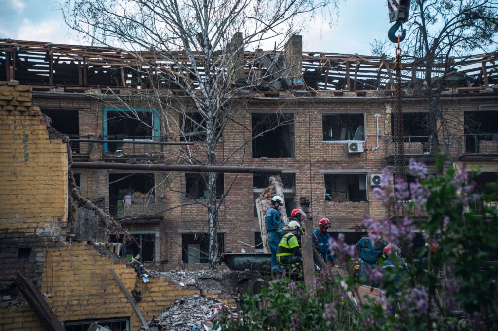 Firefighters in Kyiv inspect a damaged building after an attack, highlighting the devastation of war.