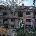 Firefighters in Kyiv inspect a damaged building after an attack, highlighting the devastation of war.