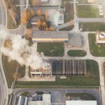 Aerial shot of an industrial area with visible smoke emissions in Poznań, Poland.