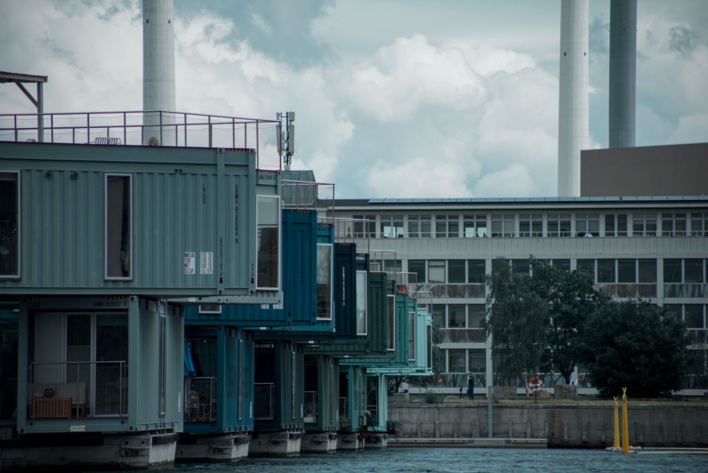 Colorful container homes on an urban waterfront showcasing modern architecture and industrial design.