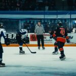 Dynamic ice hockey game captured during a faceoff in a Buenos Aires indoor arena.