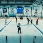Indoor ice hockey game at the Olympic-themed arena in Buenos Aires with teams in action.