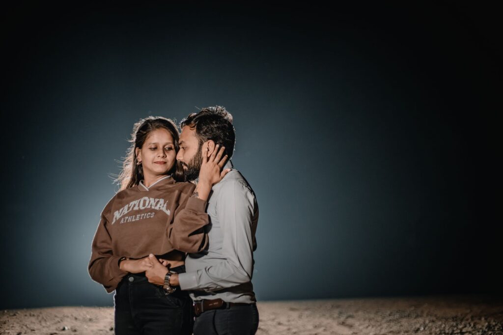 A couple shares a tender moment under a night sky, showcasing love and connection.