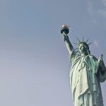 Low angle view of the Statue of Liberty against a clear blue sky, symbolizing freedom in New York.