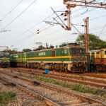 Electric locomotives of Indian Railways on tracks during sunset, showcasing the railway infrastructure.