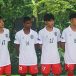 Four soccer players in uniform standing outdoors, ready for a match in Myawaddy, Myanmar.