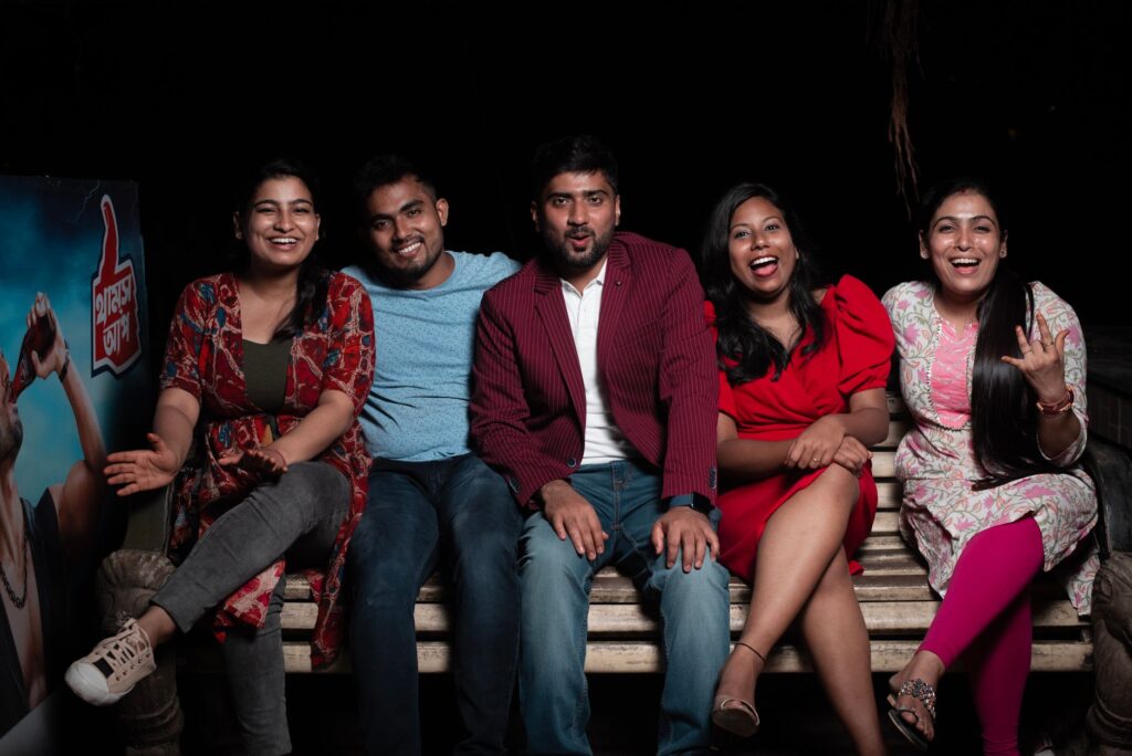 Five friends enjoying an evening on a bench, sharing laughter and good times.