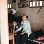 Two elderly women sharing a joyful moment in a cozy room setting, showcasing warmth and companionship.
