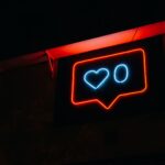 Bright neon heart icon with zero likes, symbolizing social media engagement.