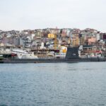 Panoramic view of Istanbul harbor showcasing a historical submarine against colorful cityscape.