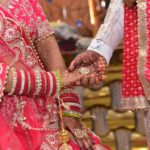 Close-up of a colorful Indian wedding ceremony featuring intricate henna designs and traditional attire.