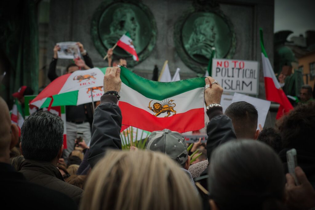 Protest in Stockholm with Iranian flags and social issue slogans.