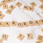 Labor Day spelled with Scrabble tiles on a marble surface, symbolizing celebration and creativity.