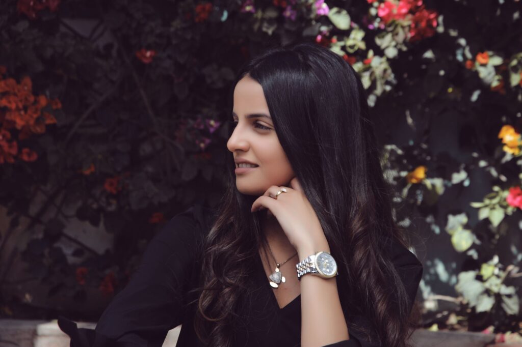 Stylish woman in Casablanca enjoying a moment outdoors surrounded by vibrant flowers.