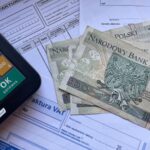 Polish currency placed on invoices with a calculator, illustrating financial transactions or budgeting.