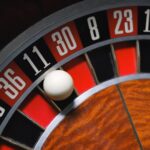 Detailed view of a roulette wheel with a ball, emphasizing the excitement of gambling.