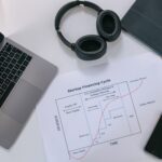 Flat lay of a modern workspace with tech gadgets and a startup financing cycle chart.