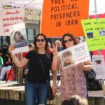 Participants at a Vancouver protest advocating for political prisoners in Iran hold banners and placards.