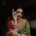 A woman in traditional sari holds a lime in a dimly lit market setting, exuding grace.