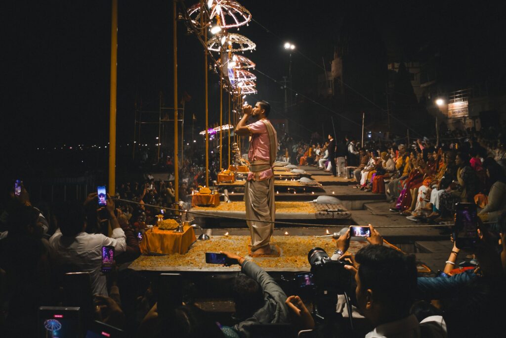 Night view of the traditional Ganga Aarti ceremony in Varanasi, with priests performing religious rituals along the riverbanks.