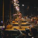 Night view of the traditional Ganga Aarti ceremony in Varanasi, with priests performing religious rituals along the riverbanks.