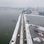 Aerial shot of a snow-covered bridge and road in Srinagar, Kashmir, during winter.