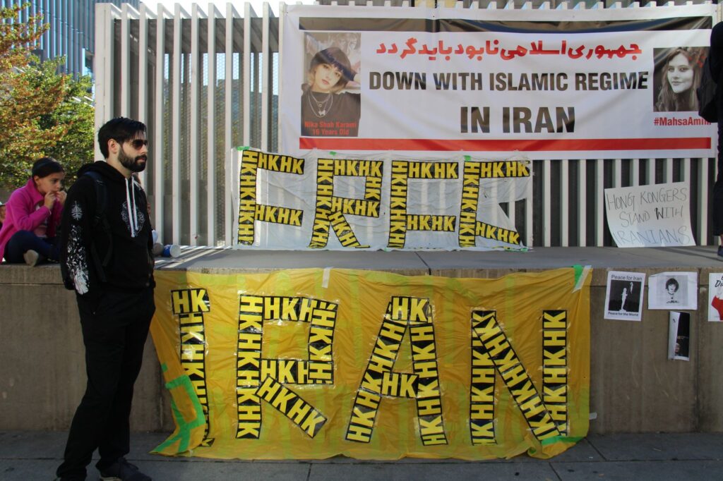 Peaceful protest in Vancouver advocating against the Islamic regime in Iran. Features banners and demonstrators.