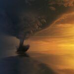 A powerful tornado over the ocean during a dramatic sunset, capturing the storm's intensity and beauty.