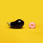 Vibrant conceptual art symbolizing sexual education using eggplant and donut on yellow background.