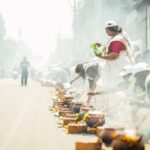 Women in traditional attire participate in outdoor cooking festival.