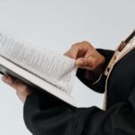 Close-up of a priest reading from a Bible book during a religious service.