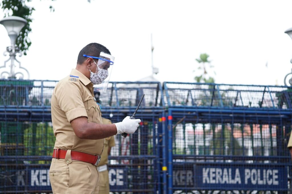 A police officer in Kerala, India, equipped with safety gear, focuses on public security.