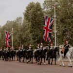 Ceremonial cavalry with Union Flags in a historical parade on The Mall, London.