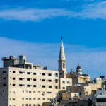 Scenic view of Bethlehem buildings with a prominent church spire under a bright blue sky.