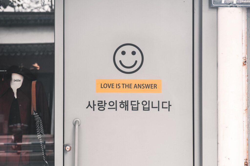 Grey door with a smiley face and 'Love is the Answer' text in English and Korean.
