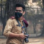 Portrait of a masked photographer amid the outdoors in Dhaka, showcasing urban exploration.