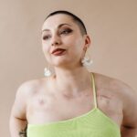 Elegant portrait showcasing a confident woman with earrings and unique beauty marks, highlighting strength.