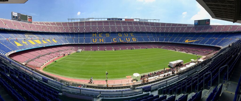 Panoramic view of Camp Nou stadium showcasing its iconic seating and field.