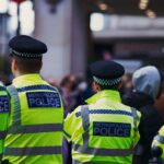 Metropolitan Police officers in high-visibility jackets on patrol in London.