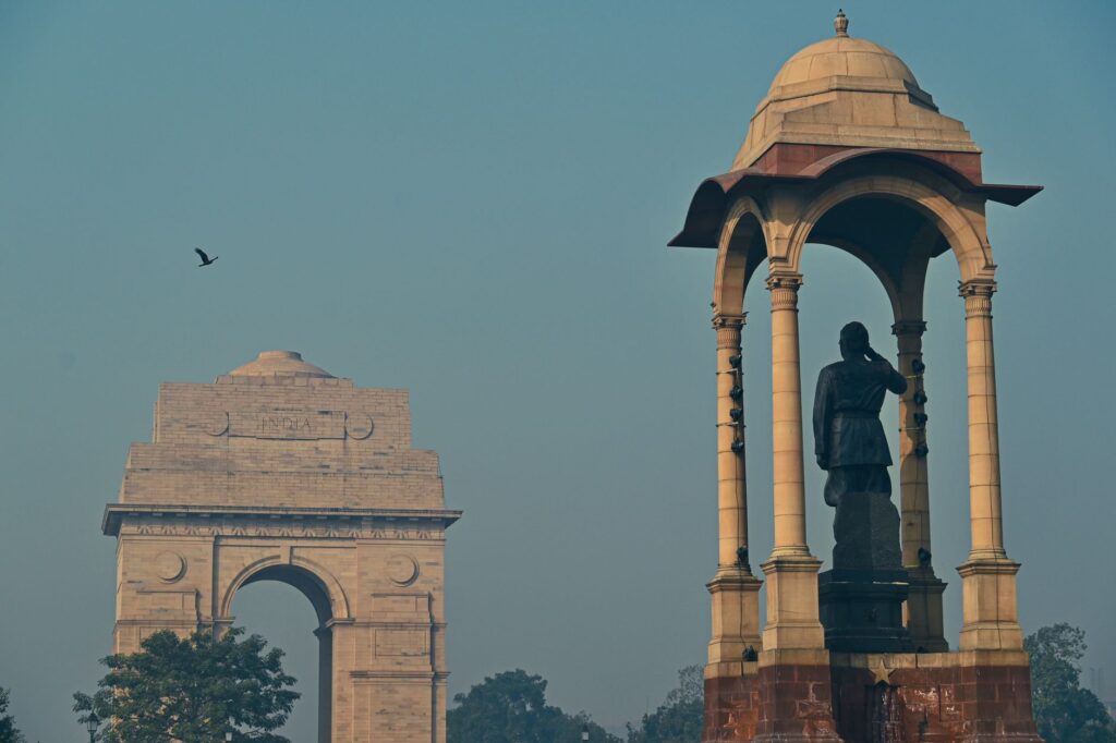 View of the iconic India Gate monument with nearby canopy in New Delhi.