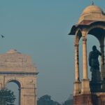 View of the iconic India Gate monument with nearby canopy in New Delhi.